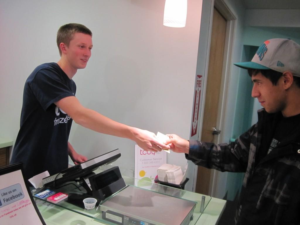 Ethan Leonard, a senior at FRHS, accepts a bill for a transaction at his work, TCBY frozen yogurt on College. Photo credit: Elliott Smith.