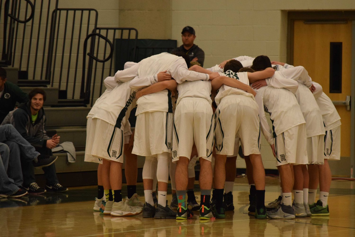 Fossil Ridge basketball team huddle before their second tournament game. Photo Credit: Haley Rockwell.  