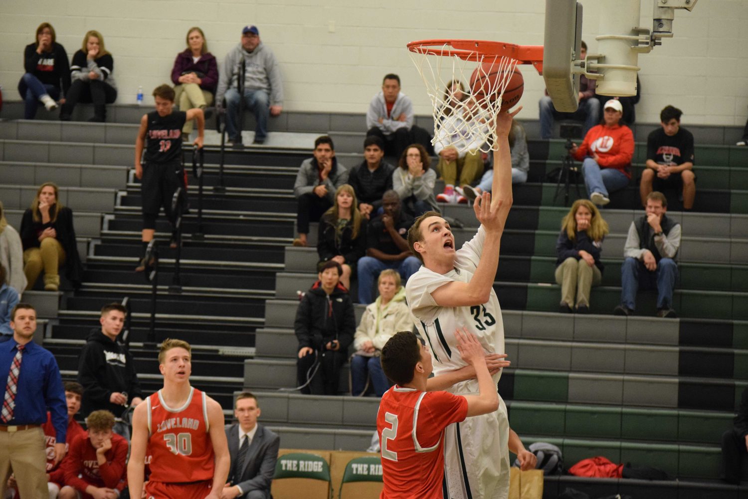 Cam DeHart jumping up for a layup against Loveland High School defender. Photo Credit: Haley Rockwell. 