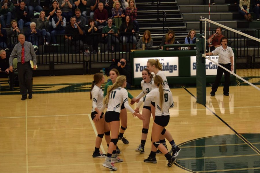 The Sabercats celebrate the point that earned them back the lead over Eaglecrest. Photo Credit: Haley Rockwell