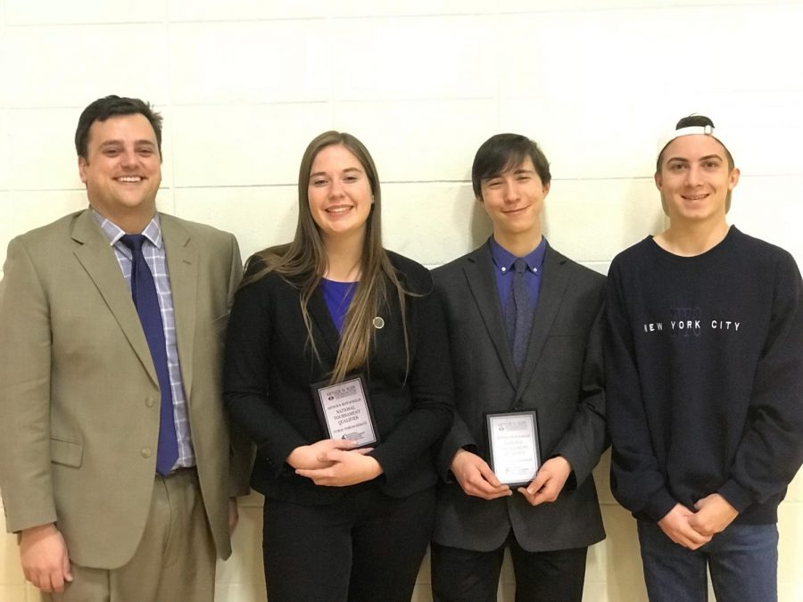 Public Forum team of Holly Ryan and Ethan Sherman pose with their coaches Grant Campbell and Chase Julian.