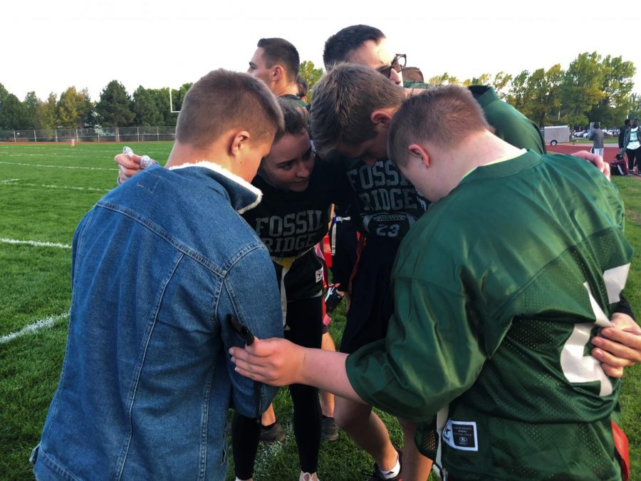 Members of the Unified team huddle on the sideline.