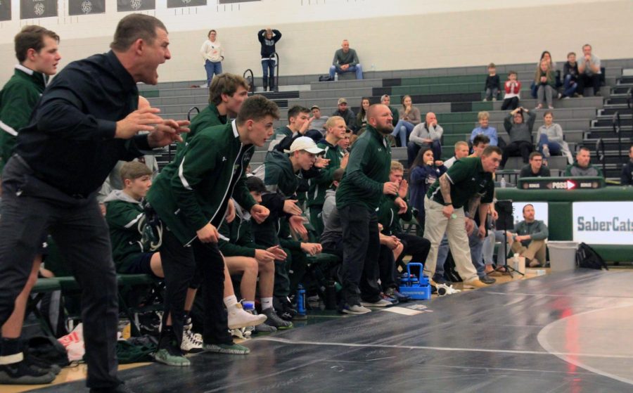 Fossil wrestlers and coaches cheer for Parker. 