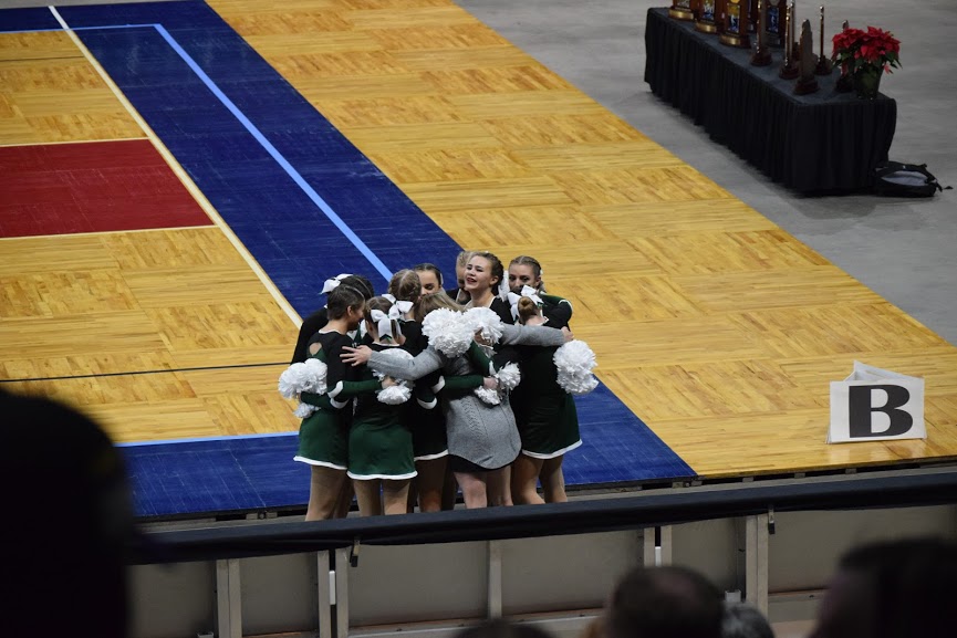 Immediately after finishing their routine, the team runs off the floor to hug Coach Billie.