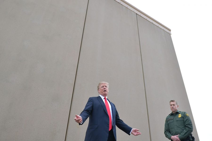President Trump standing in front of a wall. 