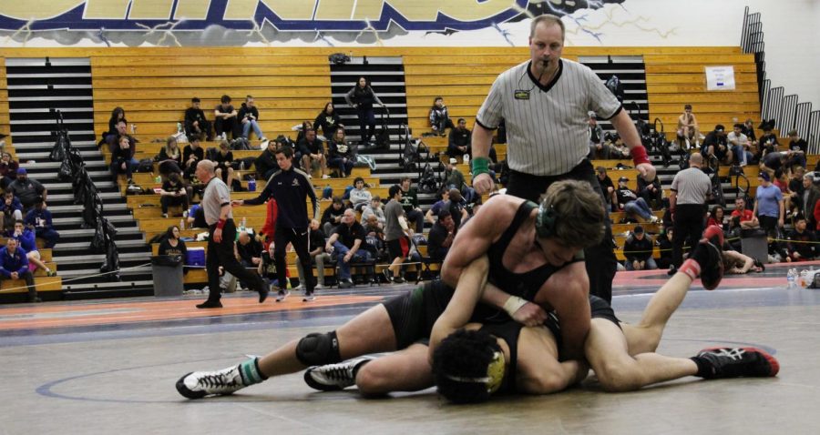 Parker pushes his opponent to the mat. 
