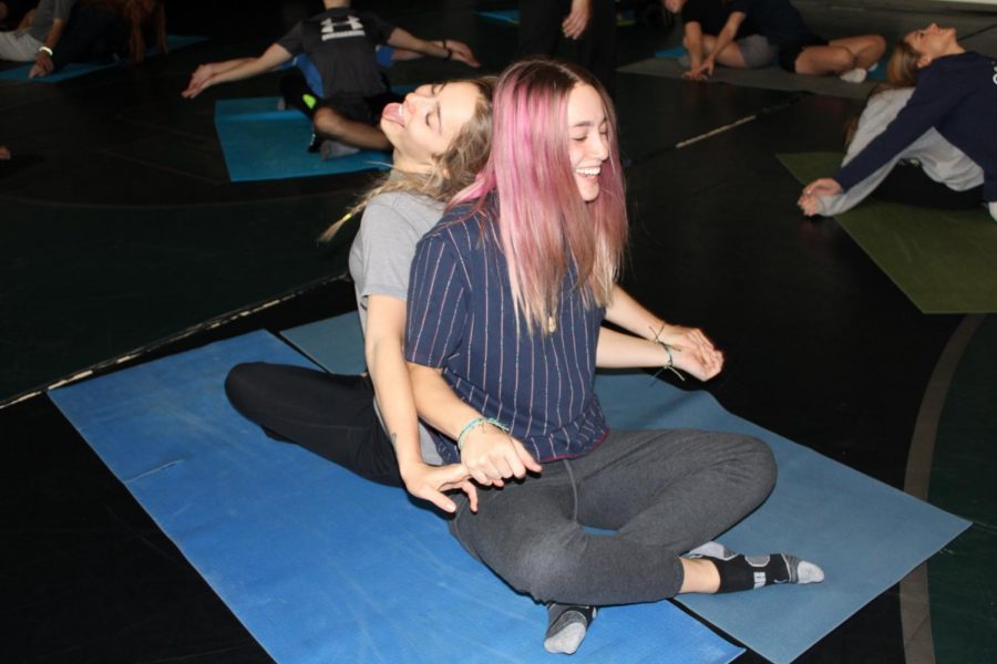 Alena and Gigi Leberger are sharing laughs while practicing yoga poses.