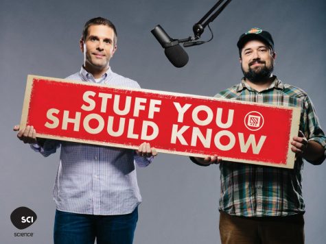 Clark (left) and Bryant (right) with the title of their podcast that has been in production for over a decade. 