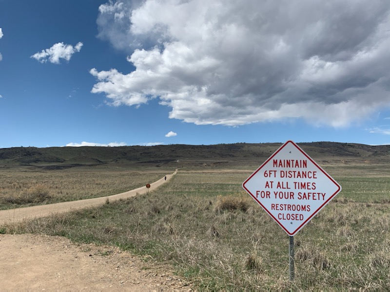 Signs warn hikers to distance themselves from others on the trail.