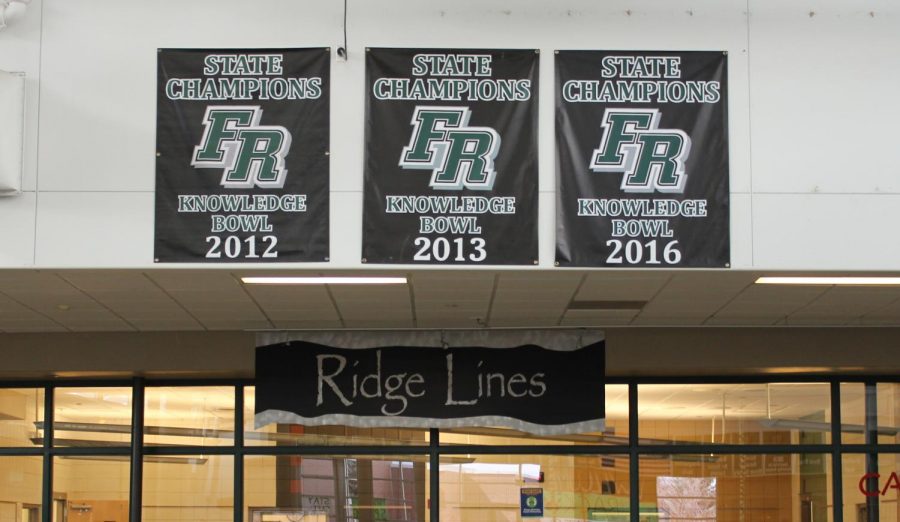 Three Knowledge Bowl state banners hang, waiting to be joined by the fourth. 