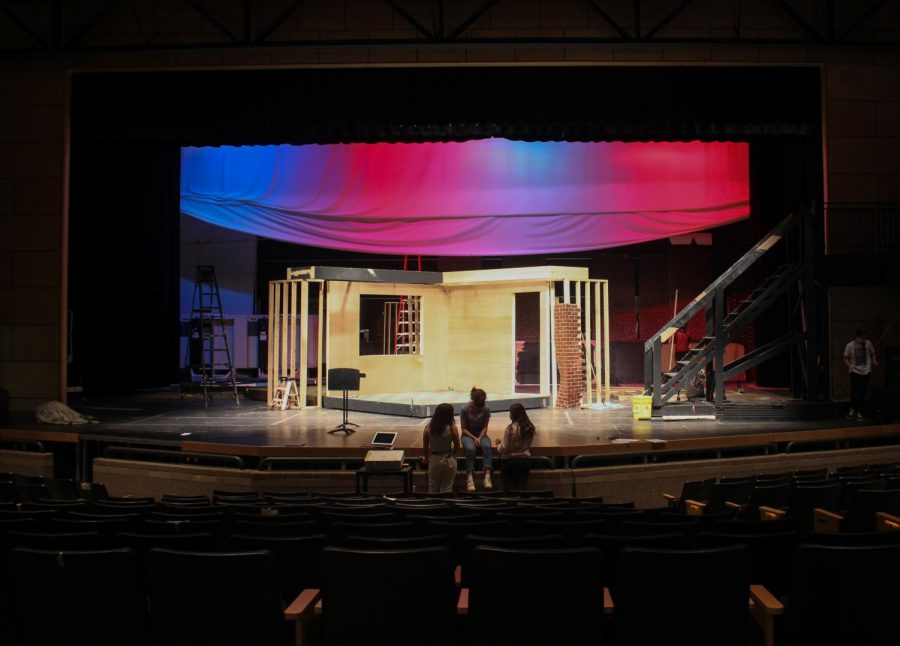 Students talk in front of the set, which is currently being built.
