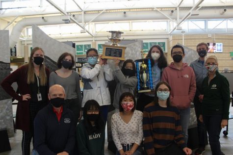 Fossil's Knowledge Bowl team proudly holds the symbols of their hard work in the air.