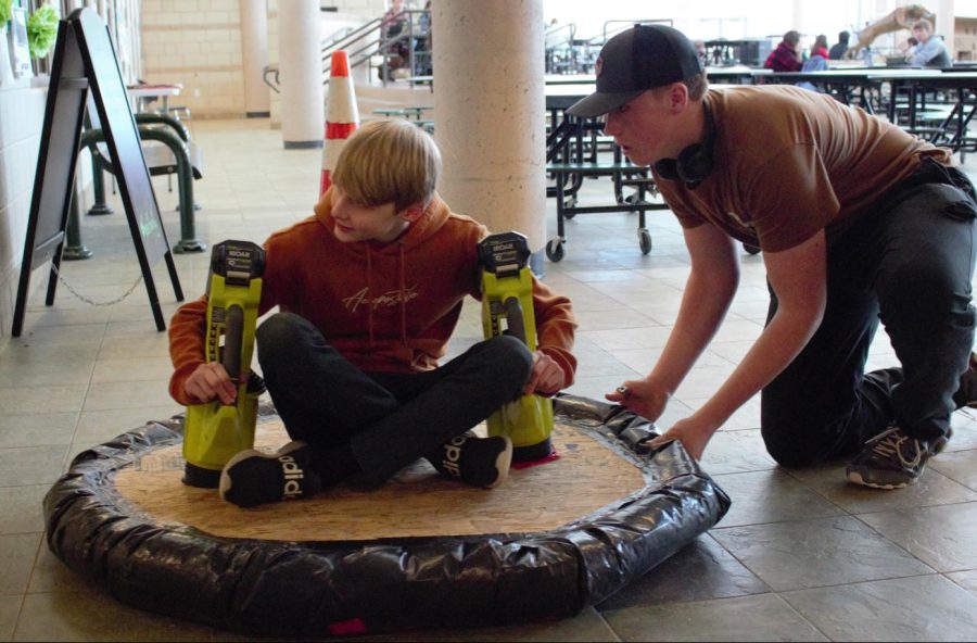 Tyler Jamison, a freshman, gets pushed by a classmate on their handmade hoverboard.