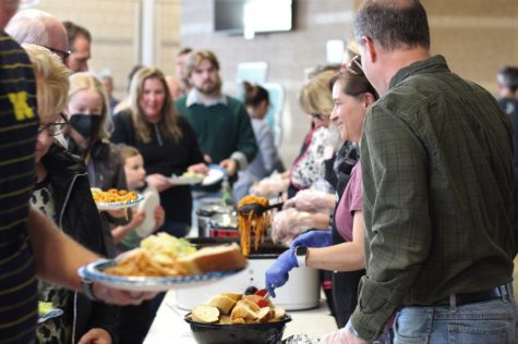 Participants come up to the buffet style table to fill their plates.