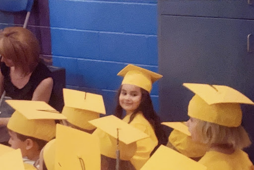 Me wearing my yellow cap and gown, ready to graduate kindergarten. 