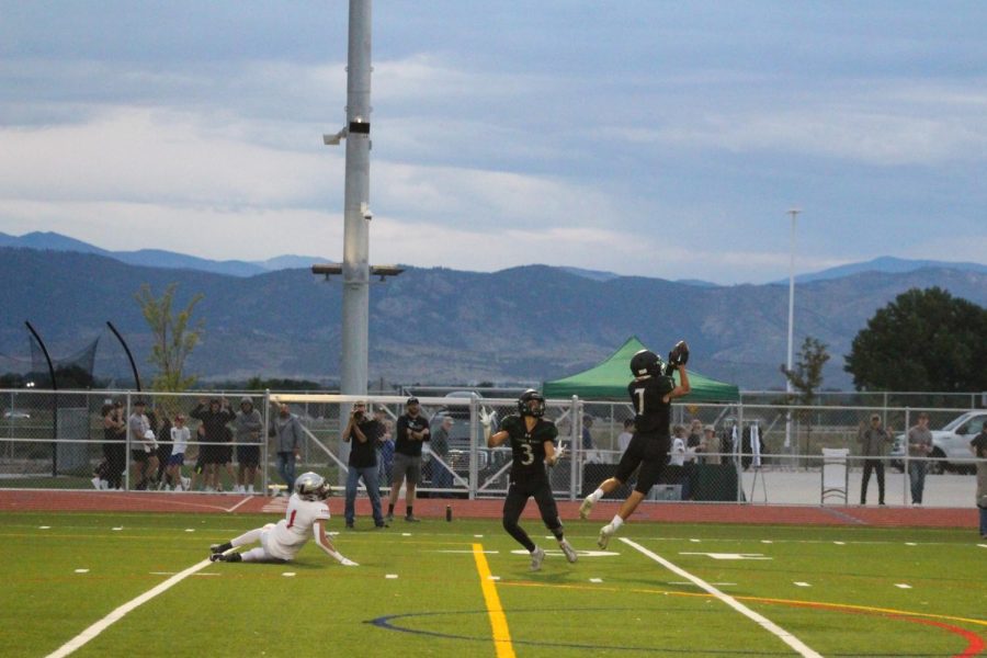 Cornerback Ryan Pollyea picking off a pass in front of a scenic mountain backdrop.