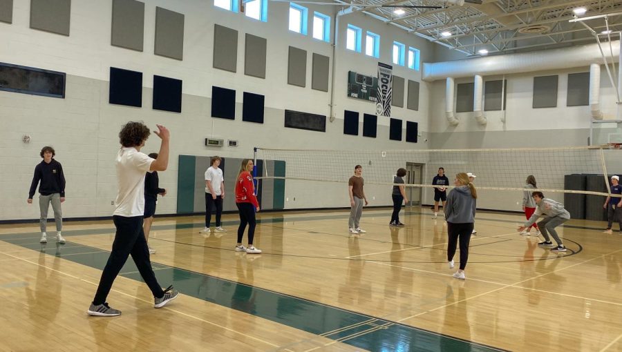 Students in the small gym participating in a friendly game of volleyball. 