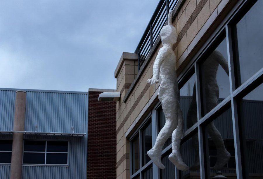 Out in the courtyard of Fossil, another statue grasps the ledge, hanging from the balcony. 
