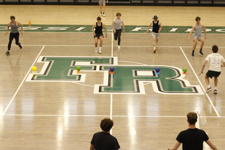 A team runs to collect all the dodgeballs in the center as the game begins.