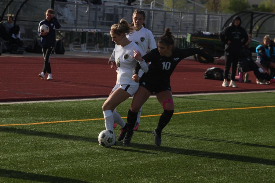 Sophomore Abby Ballek attempting to fight off a Rock Canyon defender.