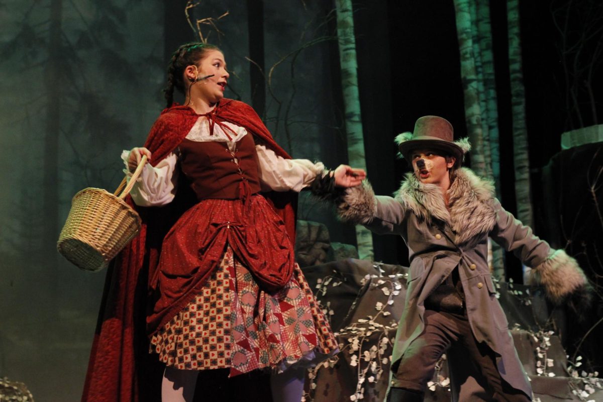 The Wolf (Clark Barry) persuading Little Red Riding Hood (Karoline Maloy) to get off the path to Grannys house.