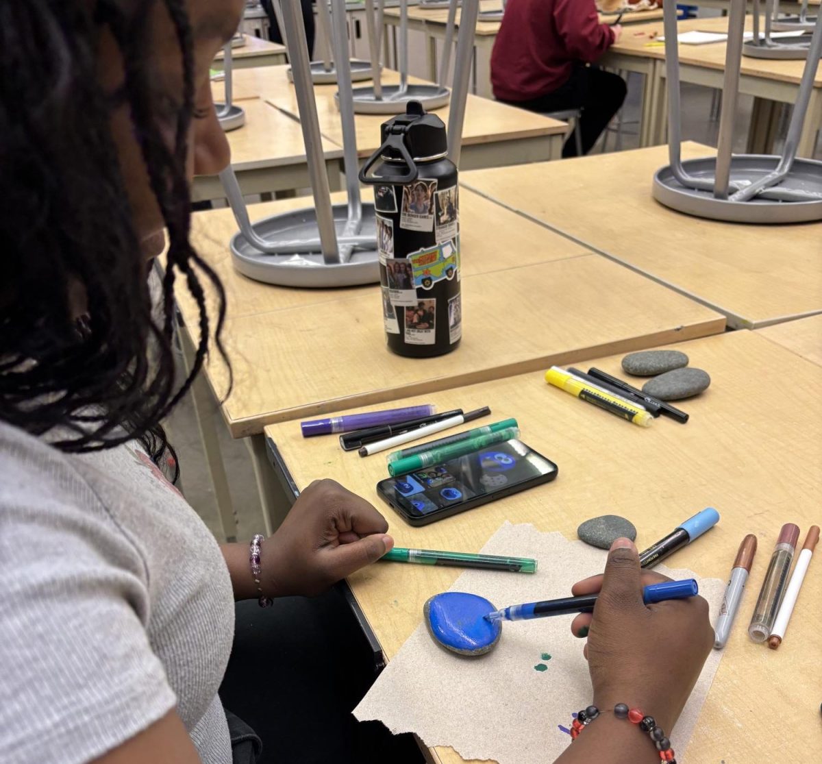  Freshman Tamara Whittaker works on a rock painting project on Monday at Art Club.