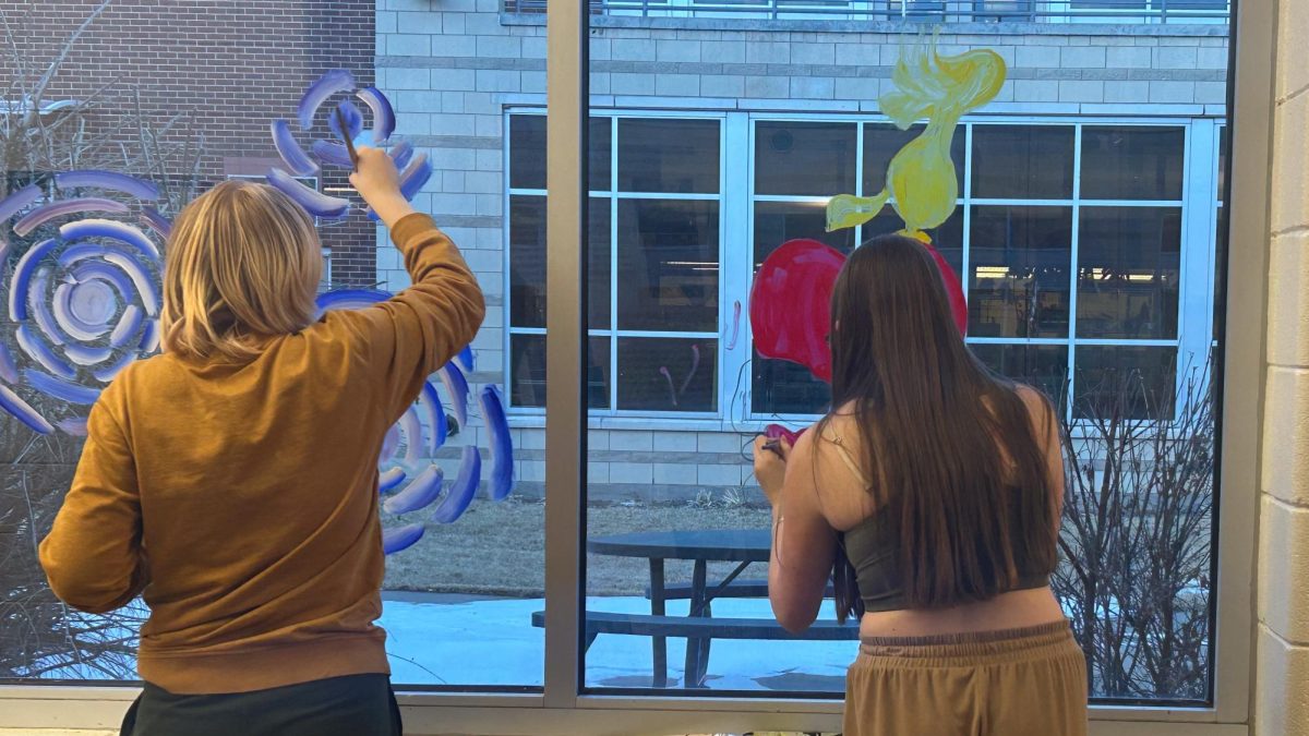 Adelaide Kaufman and Mckenna Clark paint the window.