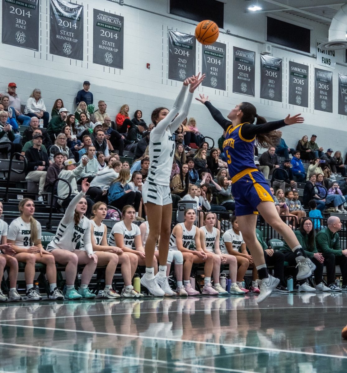 Lauren Smith shoots a three pointer with a defender in her face on Wednesday night against Denver North in play-in game.