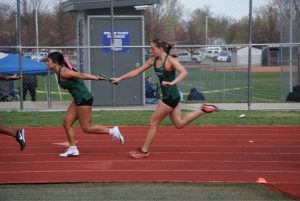 After running the first 100m in the relay, Lucia Tompkins hands off the baton to Nicole Ghose in the girls 4x100 event. (Dani Cook)