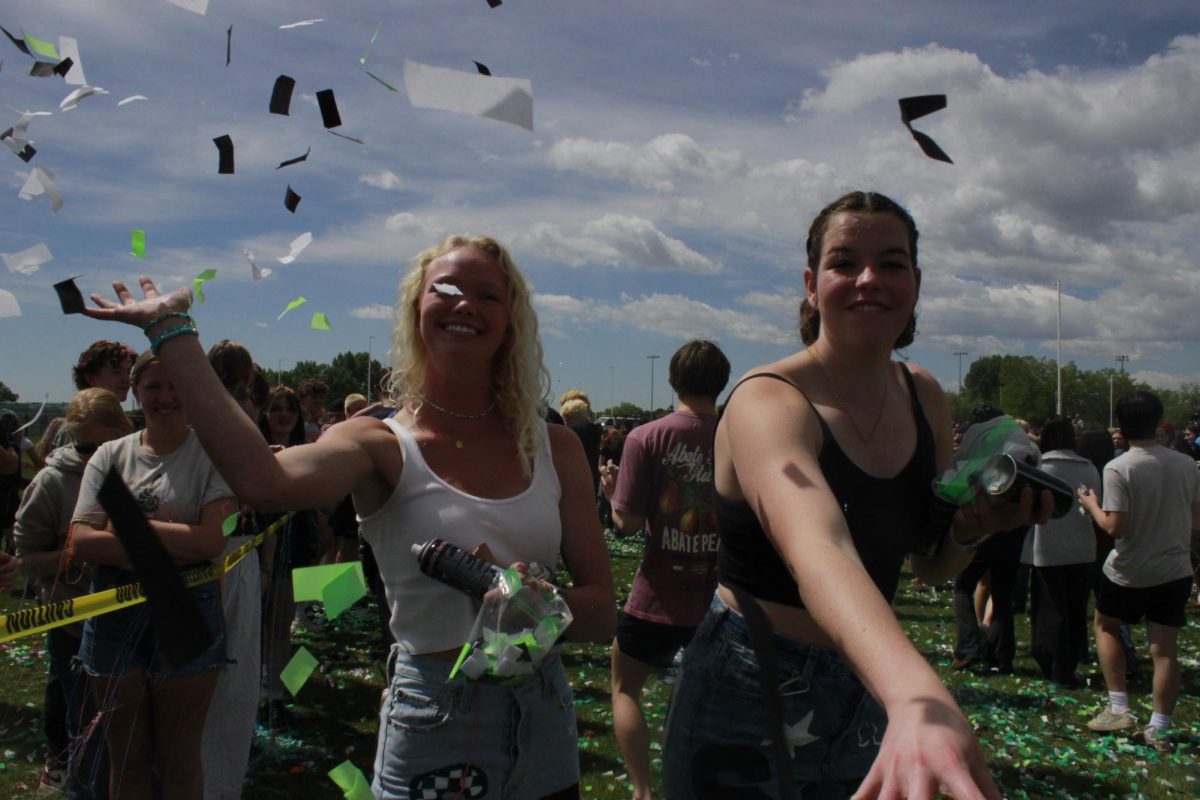 On their last day of senior year, Tatum Berg and Rachel Rankin throw confetti at the camera.