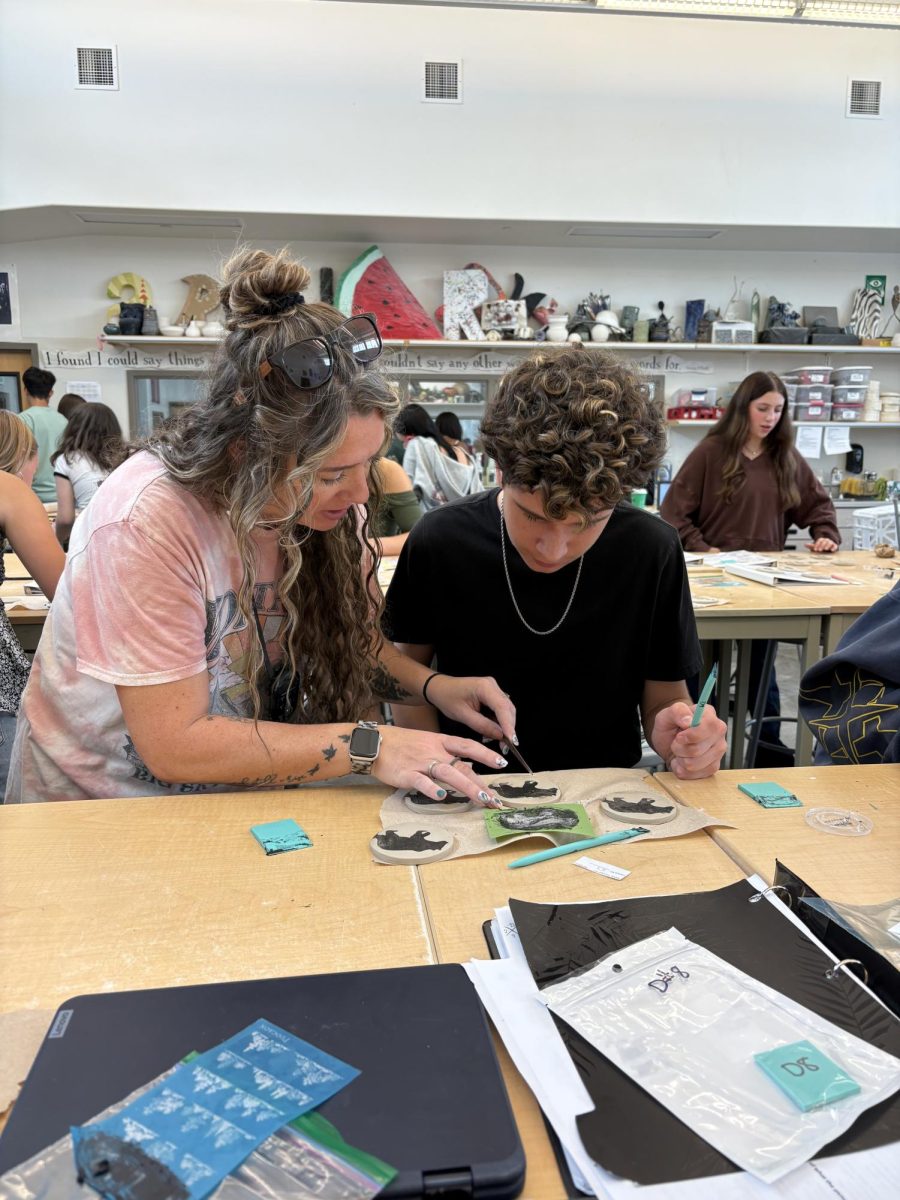 Fossil Ridge High School teacher Evanne Nasypany helps freshman Guilherme Zerbinatti solve problems on his project.
