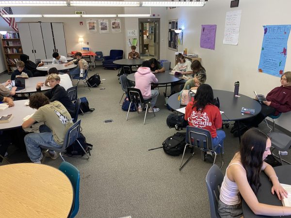 Students sit in circle groups in E102.
