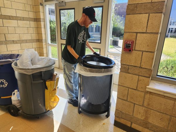 Benjamin Suggs empties a trash bin in the East Wing.