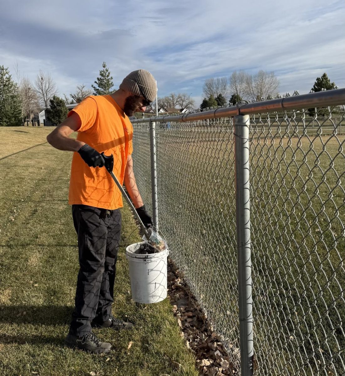 A city worker picks up trash at Twin Silos Park recently.
