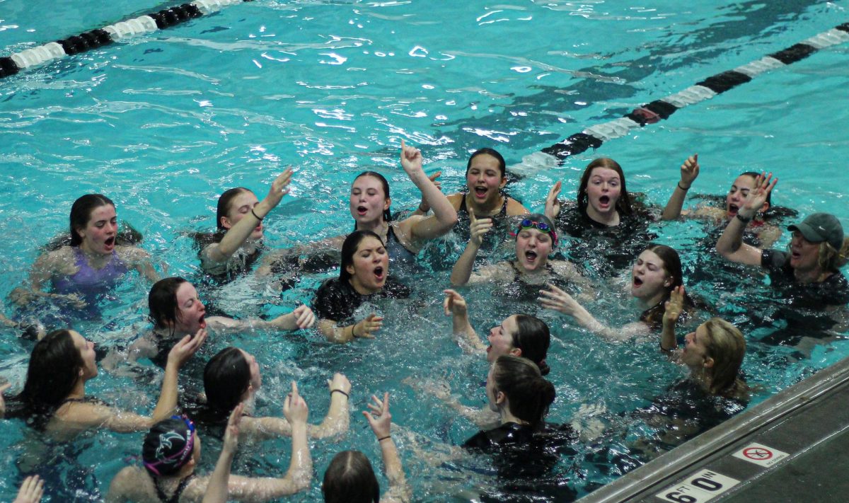 Girls swim and dive celebrates conference with energetic chant.