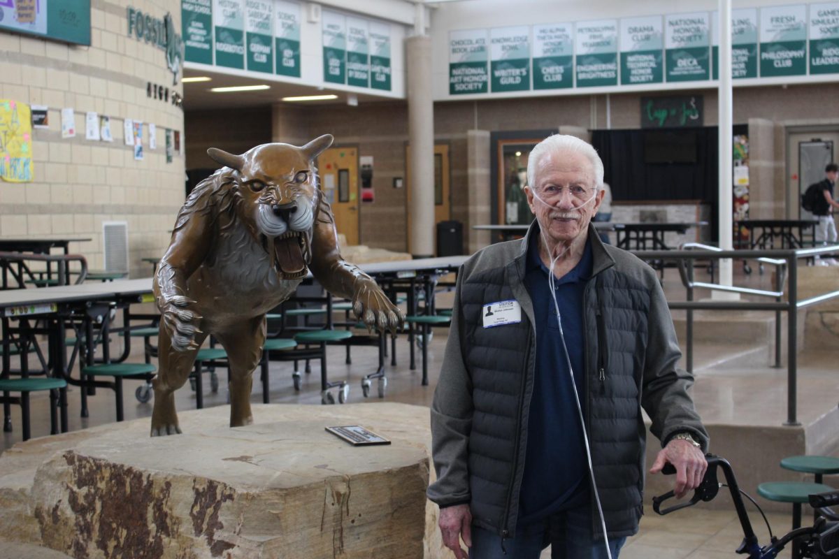 Walt Johnson stands next to the Sabercat statue at his recent visit to Fossil. 
