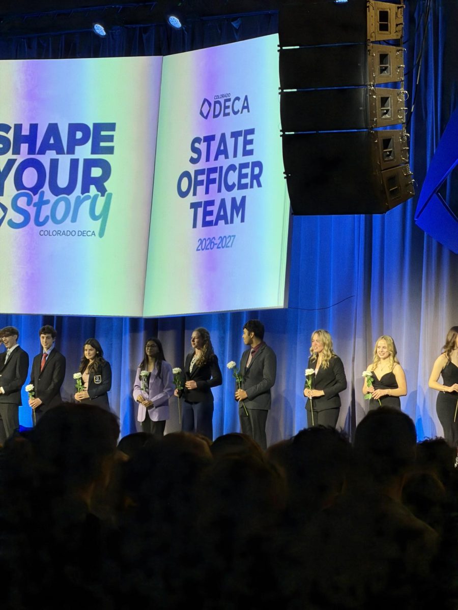 Sachit Srinivas accepts a white flower on stage for being awarded a state officer position for next year on February 24, 2026.