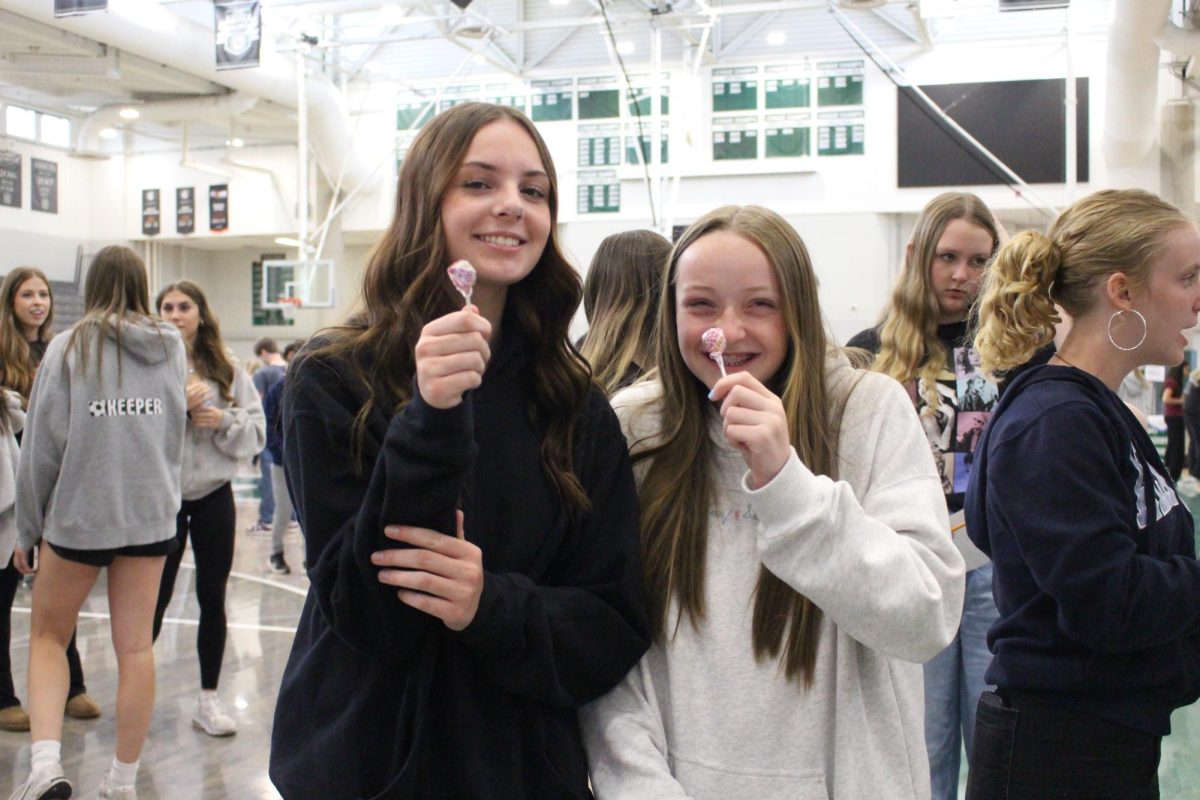 Lucy Cole (left) and McKinley Zeilke (right) smile with their lollipops. 