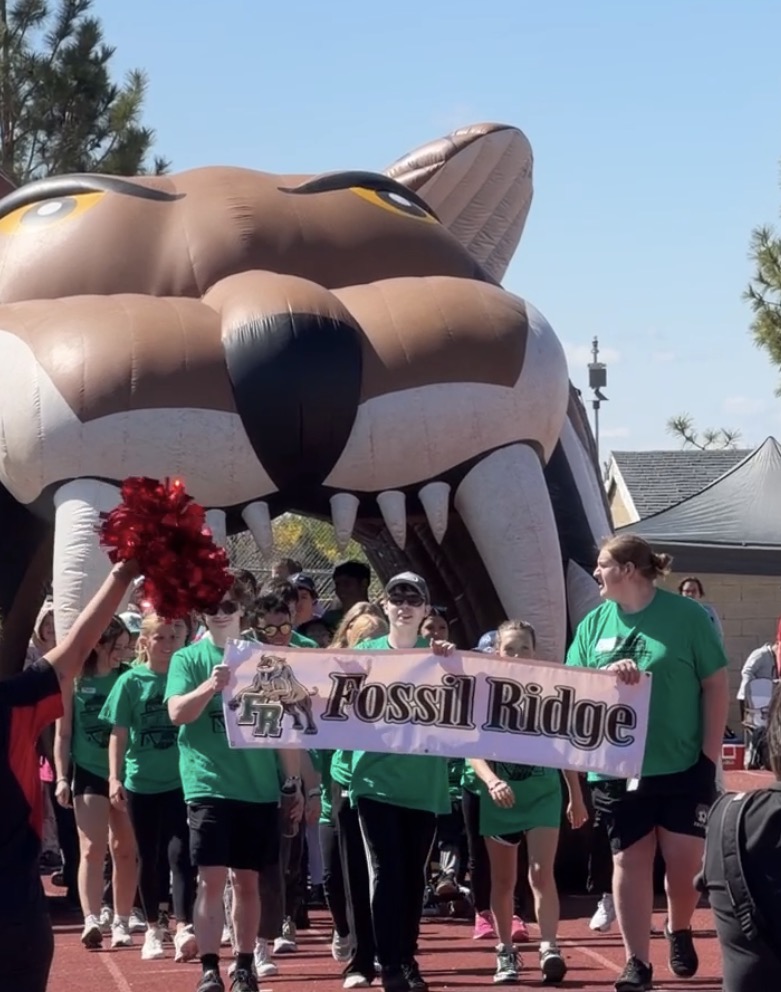 Fossil Ridge students walking with their school banner down the track, during the opening ceremony.